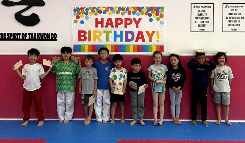 Party kids holding their broken boards under a Happy Birthday banner