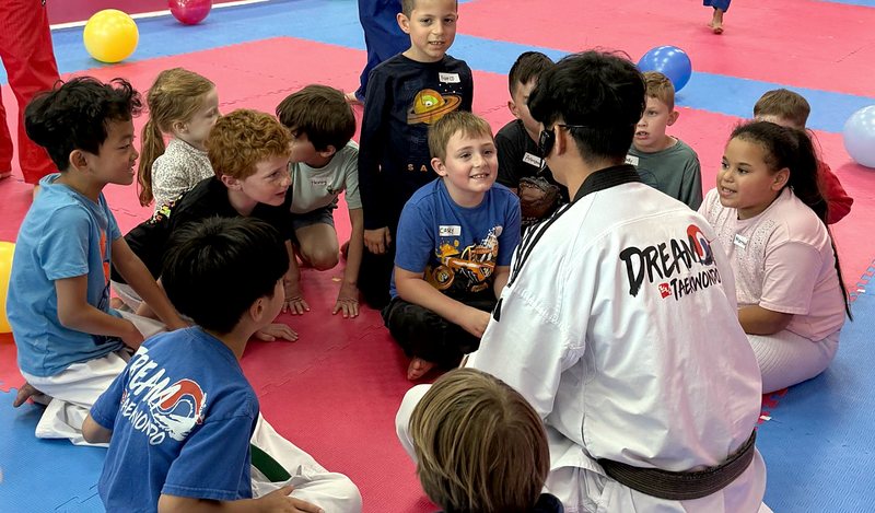 Instructor leading party games with kids sitting in a circle